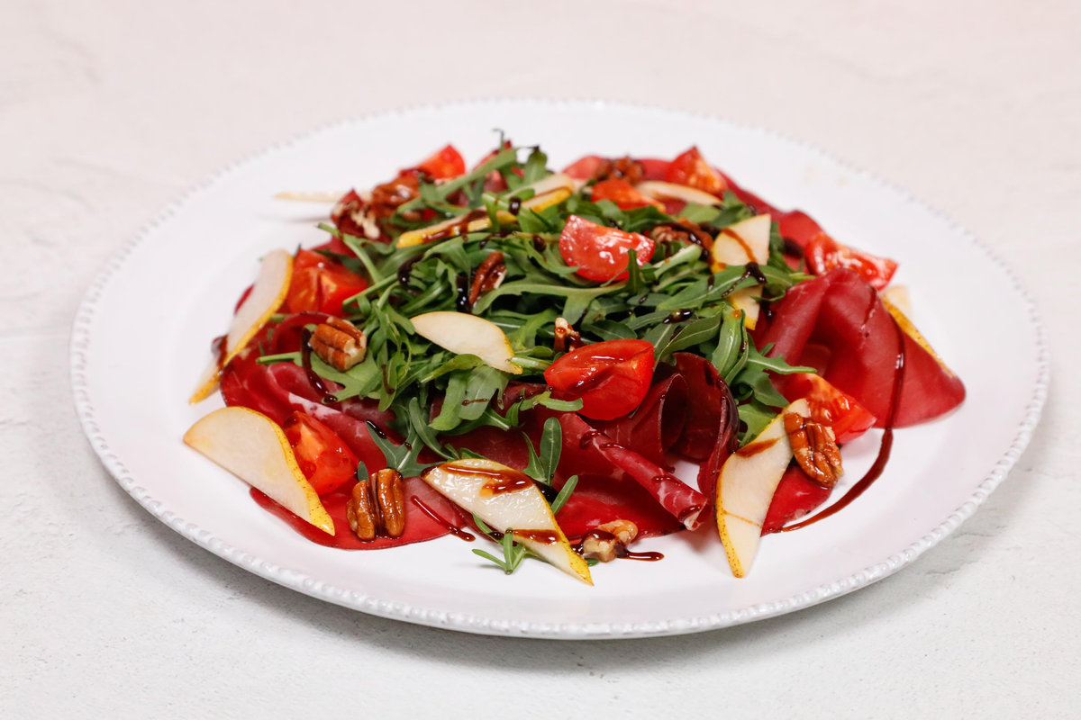 Insalata con bresaola, rucola, pomodori, frutta secca e aceto balsamico