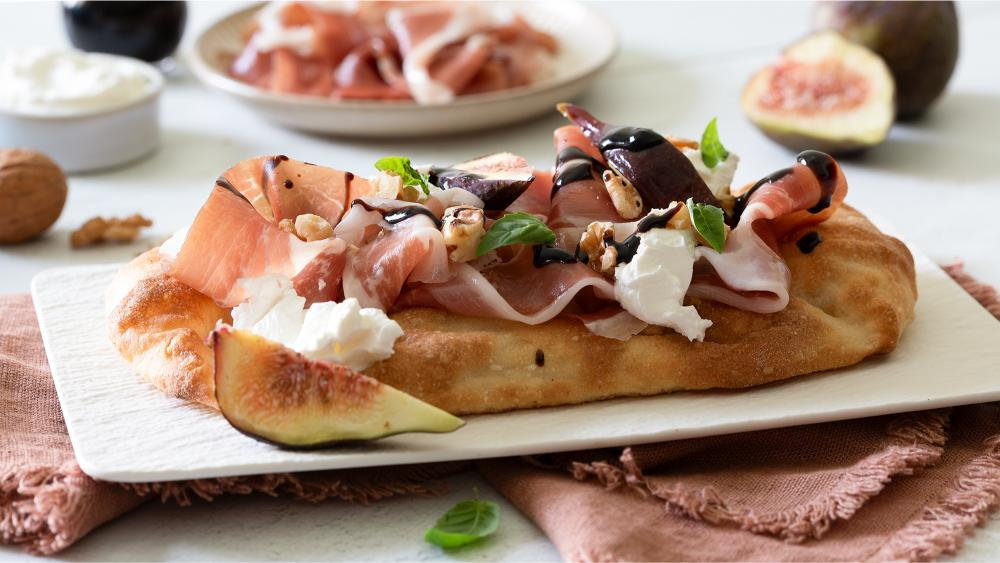 Pinsa con robiola, fichi, prosciutto di Parma, noci e riduzione al balsamico