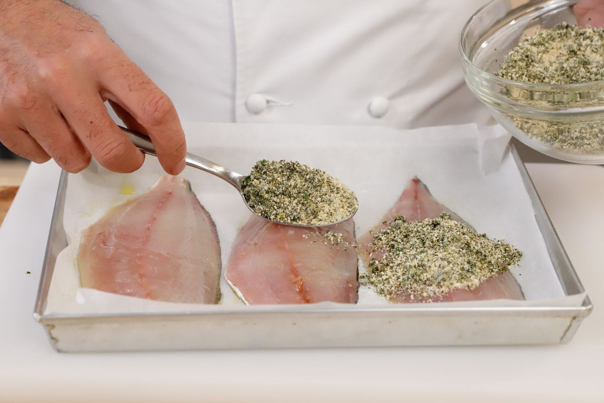 ricoprire il pesce con il pangrattato